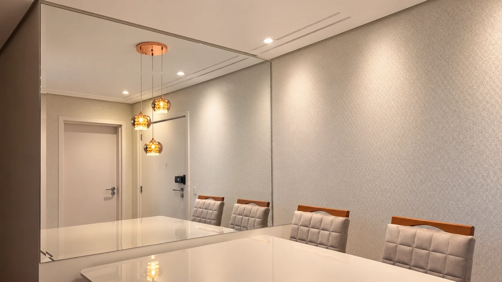 Espelho de parede inteira na sala de jantar, refletindo o lustre