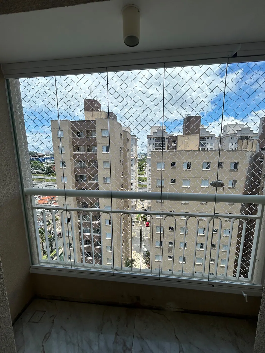 Sacada fechada com vidro e vista da cidade